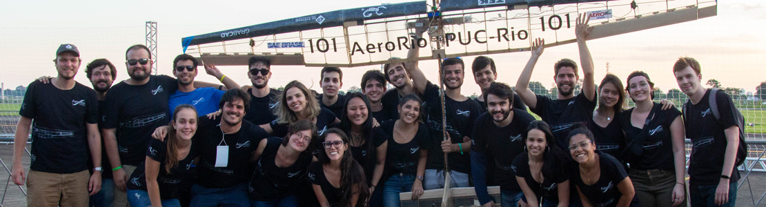 Foto da equipe segurando o avião após o fim da competição.