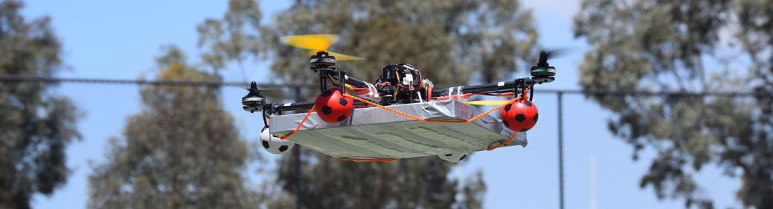 Drone carregando caixa enquanto voa.