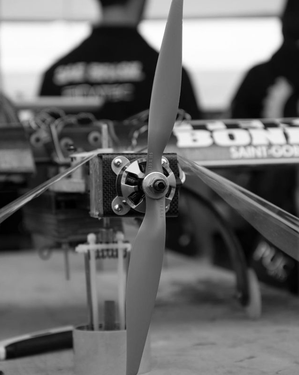 Foto da equipe segurando o avião e o troféu na cerimônia de premiação da SAE Brasil 2018.
